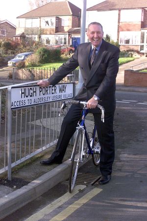 Ex-racing cyclist Hugh Porter poses with the road sign named after him on the road which leads to Aldersley Leisure Village.