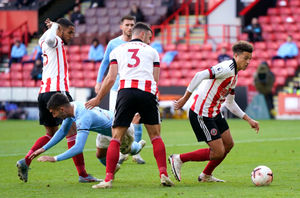 Manchester City's Ferran Torres (second left) goes down with Sheffield United's Ethan Ampadu coming away with the ball