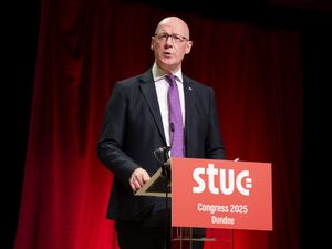 John Swinney at a podium addressing the Scottish Trades Union Congress