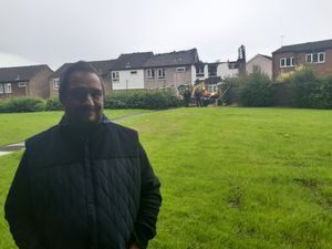 Local resident Ben Thomas knocked on neighbours' doors to alert them to the fire. The damaged houses are pictured in the background