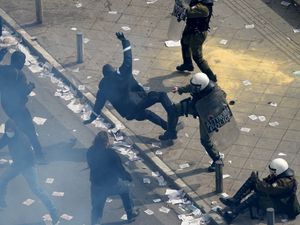 Protesters clash with riots police outside the parliament