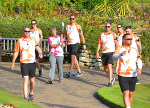 Baton-bearer Sally Johnson carries the Baton through The Dingle