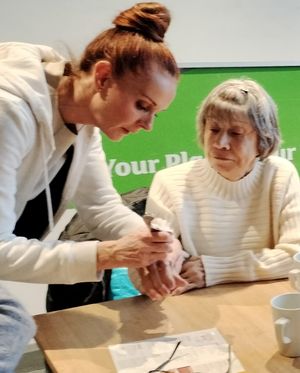 Photo attached shows Emma Louth demonstrating a treatment with Mary from the group.