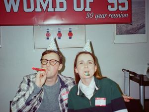 Max Fosh and Lily Hunter wearing party hats and blowing party horns
