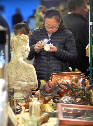 A potential buyer checks an antique.