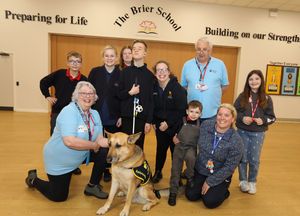 Pictured is Archie the guide dog with David Underwood (Guide Dogs) Olivia Bradshaw (Guide Dog volunteer) Miss Rosie Hatton (Assistant Head Teacher) and students from the school
