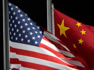 he American and Chinese flags wave