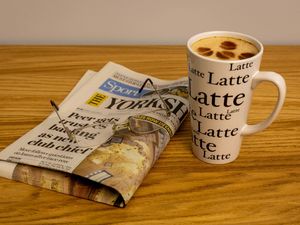 A Yorkshire Post newspaper and a coffee on a table