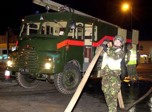 Military personnel attend a fire behind Spencers Market in West Bromwich.