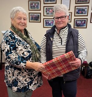 Loyal servant Tracy Bound receives her gift for reaching 100 county caps from Sybil Rhodes