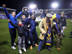 Town fans celebrate on the pitch after the match