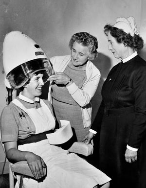 Hair we go... Matron Irene Braithwaite watches as a new hair drier at the Wrekin Hospital is tried out on Nurse Kathleen Davies of Hadley in July 1964. Placing the drier in position is Mrs Marjorie Bebb, chairman of the League of Friends.