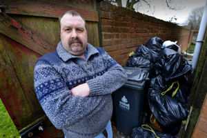 Stephen Long with the rubbish piling up at the side of his home in Walsall Wood