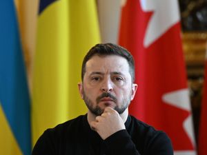 Volodymyr Zelensky in front of a Ukrainian flag