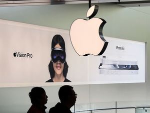 People visit an Apple Store, inside a shopping mall, in Beijing