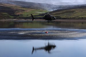 A helicopter collects water to help firefighters 