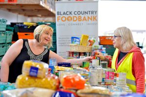Linda Lowe and Linda Sheils sorting out piles of food stacked high