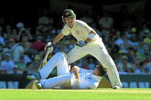 England's Graeme Swann (bottom) looks up to Australia's Brad Haddin after falling over
