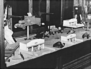 'Toy shop, Wolverhampton'. The photograph shows a shop window, including wooden tanks, planes and trains in December 1942. The store isn't named.