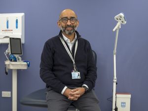 Dr Saket Priyadarshi standing next to medical equipment