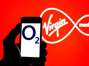 The Virgin Media logo with the O2 logo on a smartphone in the foreground