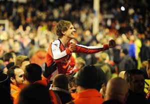 James Baxendale is held aloft by Walsall fans.