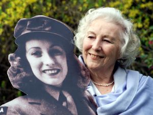 Dame Vera Lynn in 2020 with a picture of herself as a young woman