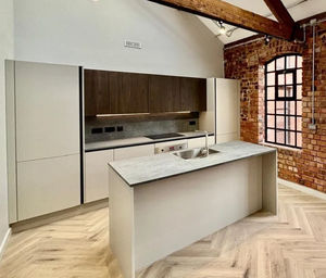 The kitchen features an exposed brick wall design and exposed roof trusses 