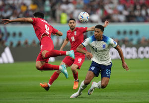 Iran's Mehdi Taremi (left) and England's Jude Bellingham battle for the ball during the FIFA World Cup Group B match at the Khalifa International Stadium in Doha, Qatar. Picture date: Monday November 21, 2022. PA Photo. See PA story WORLDCUP England. Photo credit should read: Martin Rickett/PA Wire...RESTRICTIONS: Use subject to restrictions. Editorial use only, no commercial use without prior consent from rights holder..