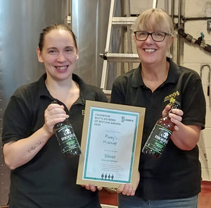 Monty’s Brewery co-founder Pam Honeyman (right) and head practical brewer Kate Thomas with the silver medal certificate and bottles of Mischief.
