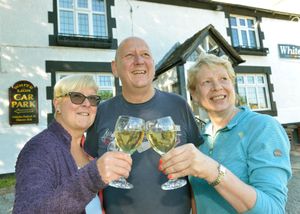 Graham Holroyd pictured with wife Ann, left and Chair of Community Group, Judith Griffin as the White Lion opens in Ash Manga, Whitchurch following a campaign by the local community