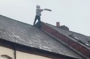 Shocking footage shows the moment a man began "launching tiles at emergency services" after clambering onto a roof during a tense standoff with police in Birmingham. 
