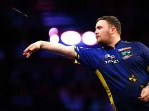 Luke Littler throws a dart with his right hand