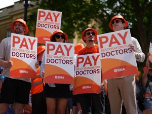 Resident doctors on a picket line protesting and holding placards