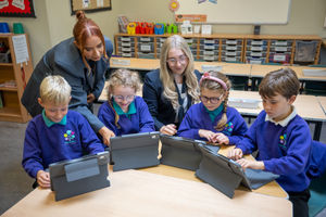 Milly Davies, teacher at Oakmeadow CofE Primary School, helping the pupils use their new IT equipment with the assistance of Sophia.