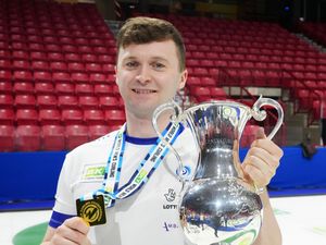 Scotland captain Bruce Mouat holds his gold medal and the trophy at the world men’s curling championships