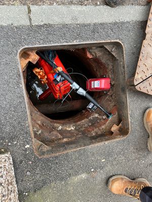 A SewerBall being lowered into a sewer.