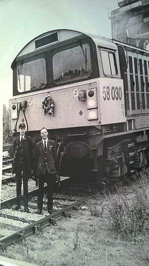 Train driver Bill Ashworth and Derek by a freightliner, 1980s