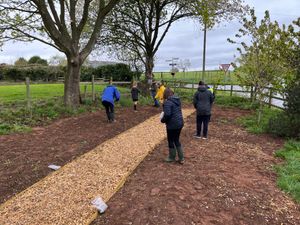 Youth Club members busy spreading wildflower seeds and planting new shrubs.