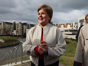 Nicola Sturgeon with hands clasped and smiling, pictured outside Holyrood