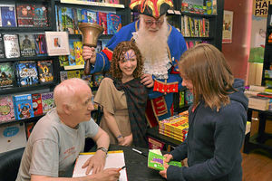 Terry Deary, left, signing a book for Hatty Ford, 11, from Lyth Hill, right, watched by Shrewsbury Town Crier Martin Wood and Waterstones worker Emma Bain, dressed as Boudica