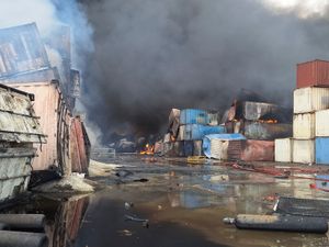 Containers burn amid thick black smoke