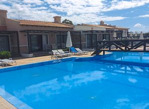 Two luxury bungalows share a large pool
