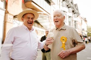 Sir Ed Davey hands an ice cream to a Liberal Democrat party supporter.