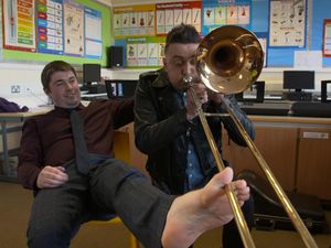 Supporting image for story: Talented teacher Osian plays cornet and two trombones with his feet – all at the same time