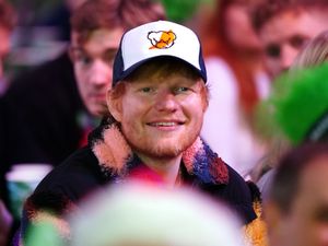 Supporting image for story: Ed Sheeran watches darts championship wearing cap with hot sauce logo