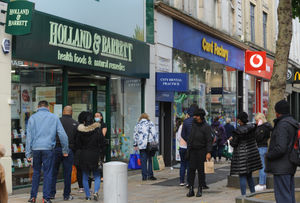 Shoppers queue outside Holland & Barrett and Card Factory
