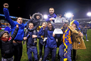 Shrewsbury Town fans celebrate on the pitch
