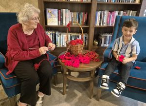 Foxland Grange care home resident and child knitting.