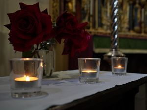 Three candles burn as members of the public attend a morning service and vigil at St James’s church in Bushey